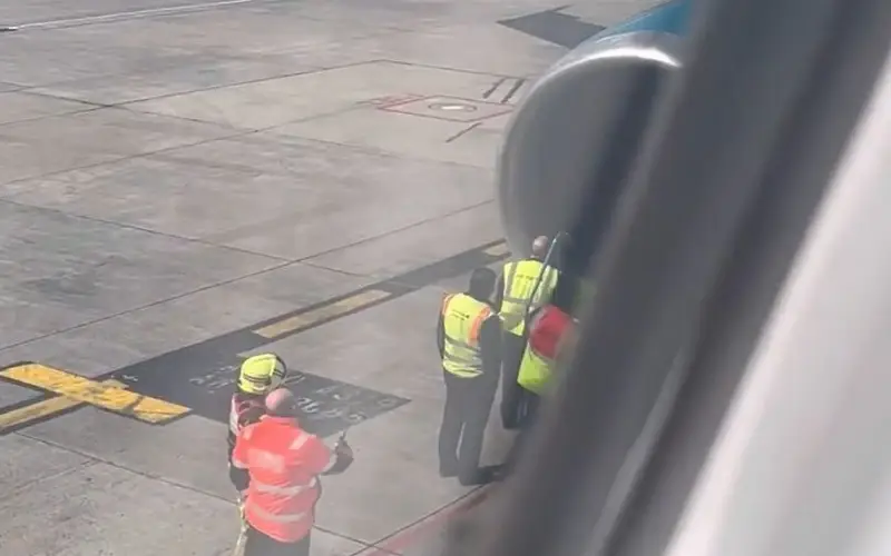 les secouristes qui inspectent le moteur droit de l’avion après son atterrissage
